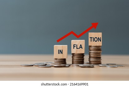 INFLATION word on a wooden cube on coins in idea for FED consider interest rate hike, world economics, and inflation control, US dollar inflation - Shutterstock ID 2164169901