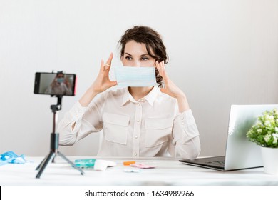 Influencer Girl Blogger In Medical Mask Talks About Coronavirus. Woman Recording Video Blog Tells How To Protect Yourself From 2019-nCov. Bloger Talks Mers-cov How To Use Of Alcohol Wipes, Thermometer