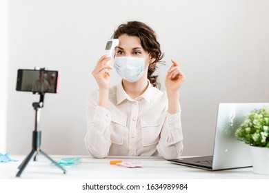 Influencer Girl Blogger In Medical Mask Talks About Coronavirus. Woman Recording Video Blog Tells How To Protect Yourself From 2019-nCov. Bloger Talks Mers-cov How To Use Of Alcohol Wipes, Thermometer