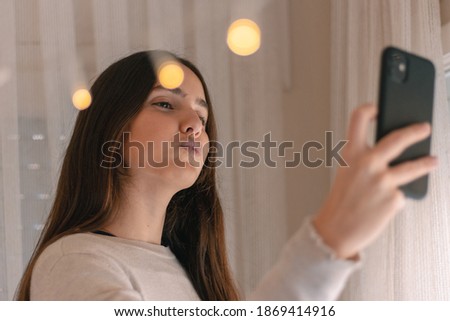 Influencer girl with mobile phone in hand taking selfie. social media content. Emotions. 