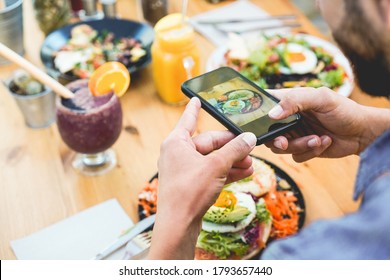 Influencer Man Eating Brunch While Making Video And Photos Of Dish With Mobile Phone In Trendy Bar Restaurant - Healthy Lifestyle, Technology And Food Trends Concept - Focus On Man Hand