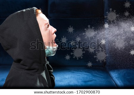 Influenza, cold, coronavirus. Infection through an airborne droplet. Girl in a hood and in a medical mask in front of a cloud of drops in the air. Visible coronavirus droplets in the air