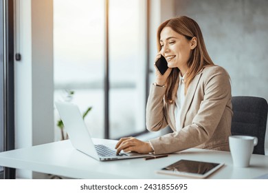 Informal Call. Happy young woman calling her friend, talking and asking about something, using laptop. Shot of a businesswoman using a computer and talking on the phone during a work.  - Powered by Shutterstock