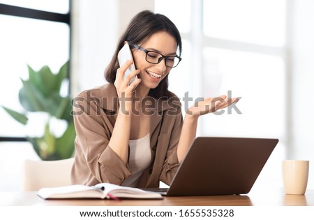 Informal Call. Happy young woman in glasses calling her friend, talking and asking about something, using laptop