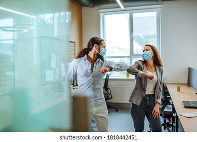 Informal Greeting Elbow Bump By Business People In The Medical Masks In The Office During Outbreak Of The Global Pandemic COVID-19. Avoiding Handshakes In A New Normal.