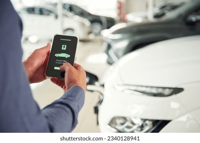 Information of charging process. Close up view of man that is with electrical car.