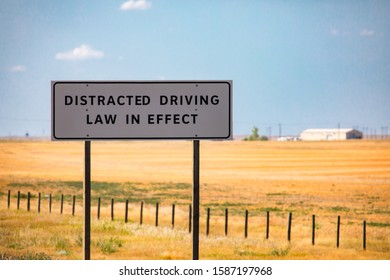 Information Road White Sign, Distracted Driving Law In Effect., On Canadian Rural Country Roadside, Against Farms And Prairies, Plains