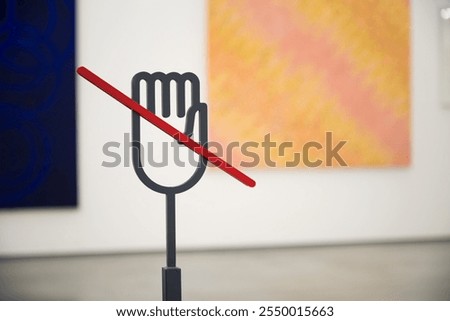 Information stand "Do not touch" symbol made from steel in modern contemporary art gallery. Prohibition, don't touch sign and symbol concept.