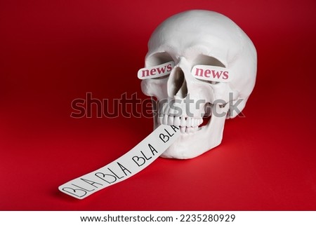 Information warfare concept. Saying useless nonsense as result of media propaganda influence. Human skull with paper cards on red background