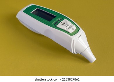 Infrared Forehead And Ear Thermometer For Baby, Adult, Hospital With Fever Alarm Isolated Painted Green On Colorful Studio Background. Object And Food Temperature Meter.