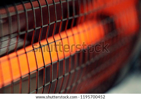Infrared heater. Cozy warmth for home. The included electric red heater close-up with a metal grill is an excellent solution in winter for heating a room.