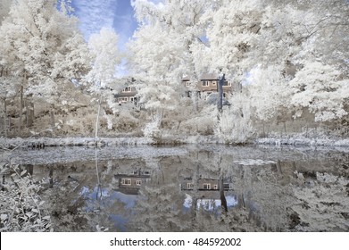Infrared landscape showing a lake with white foliage around it with a reflection in Cheshire England [infra red image]