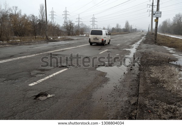 Infrastructure\
degradation. Poor condition of the road surface. Winter season.\
Hole in the asphalt, risk of movement by car, dangerous road.\
February 7, 2019. Saburb of\
Kiev,Ukraine