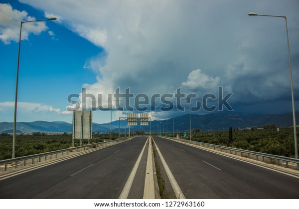 infrastructure and transportation symmetry\
photography of empty car road highway in tropic Asian world\
district in cloudy weather before\
storm