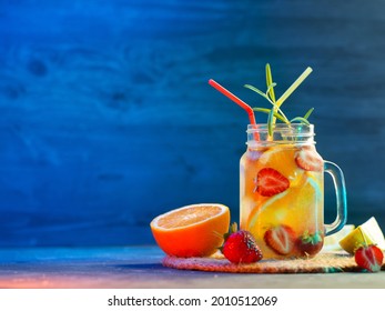 Infused Detox Water With Orange, Strawberry, Lemon And Rosemary. Summer Refreshing Drink, Colorful Bright Background