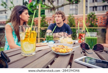 Infused fruit water cocktails and people talking in background