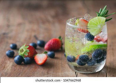 Infused water made from blueberry strawberry and lemon in sparkling mineral water look so freshness and healthy. Mixed fruit mojito on wood table with copy space. Summer refreshing drink concept. - Powered by Shutterstock