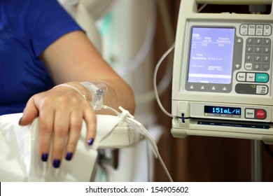 Infusion pump feeding IV drip into patients arm focus on needle