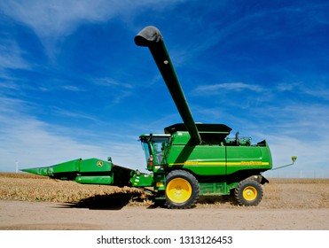 Ingalls, Kansas, USA, October 23, 2014
A John Deere Combine Sends Its Load Of Harvested Milo Grain From It's Storage Hopper Thru It's Discharge Tube Into The Bed Of A Waiting Tractor Trailer Hauler