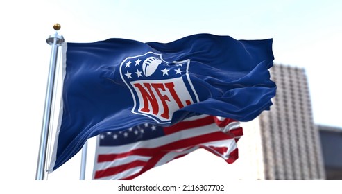 Inglewood, CA, USA, January 2022: The flag with the NFL logo waving in the wind with the US flag blurred in the background. The National Football League is a professional American football league