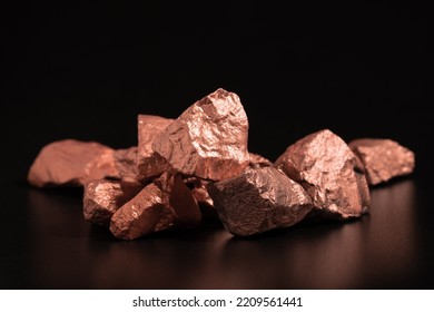 Ingots of pure copper or pink gold on a black background.