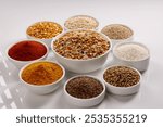 Ingredient of Popular Indian snacks Diwali Chakli around the raw Mixture of Chakali Red chili and turmeric powder rice urad dal chana dal Cumin Coriander  sesame seeds isolated on white background 