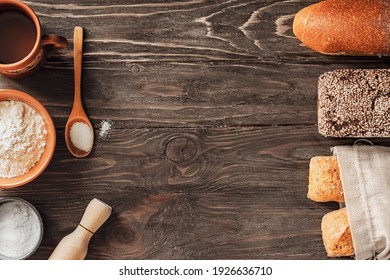 Ingredients for baking bread and assorted fresh breads on a wooden background with copy space.Healthy delicious organic food.Top view flat lay