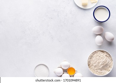 Ingredients for baking and Breakfast (eggs, flour, sugar, milk and butter) on a gray background. Concept: delicious and healthy food.