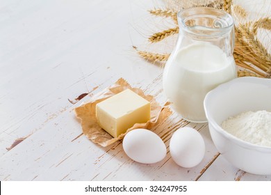 Ingredients For Baking - Milk Butter Eggs Flour Wheat, White Wood Background, Copy Space