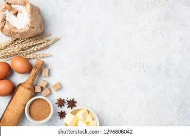 Ingredients for baking on background. Eggs, wheat flour, cubed butter, star anise, brown sugar cubes and rolling pin on concrete background with copy space - Powered by Shutterstock