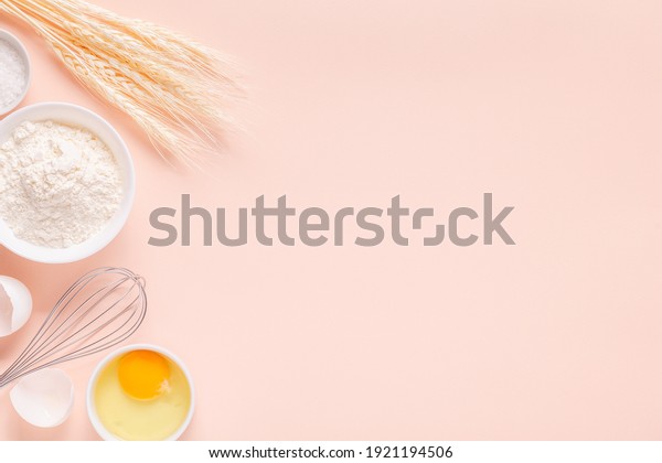 Ingredients for baking on light pink background,\
space for text.