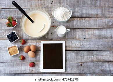 Ingredients for baking. White tablet computer with blank screen with ingredients for baking close up. Top view. Free space for text. Copy space. Food background
