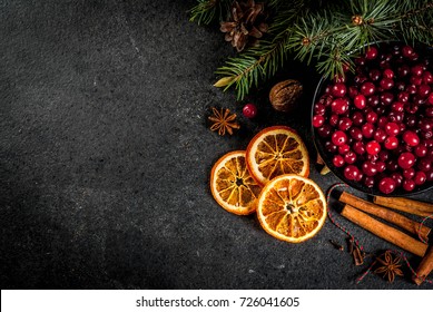 Ingredients for Christmas, winter baking cookies. Gingerbread, fruitcake, seasonal drinks. Cranberries, dried oranges, cinnamon, spices on a black stone table, copy space top view  - Powered by Shutterstock