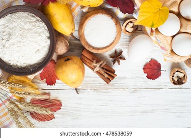 Ingredients for cooking autumn baking. Flour, eggs, sugar, pears and autumn leaves. White background. - Shutterstock ID 478538059