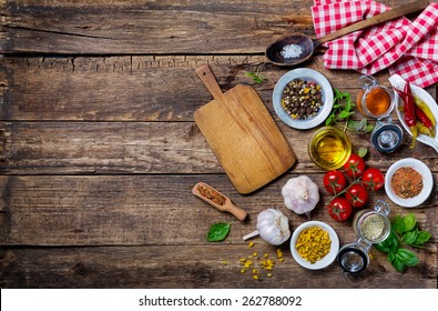 Ingredients for cooking and empty cutting board on an old wooden table. Food background  with copyspace