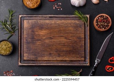 Ingredients for cooking at home: pepper, salt, rosemary, spices and herbs on a dark concrete background - Powered by Shutterstock