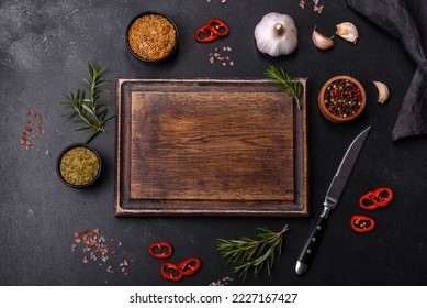 Ingredients for cooking at home: pepper, salt, rosemary, spices and herbs on a dark concrete background - Powered by Shutterstock