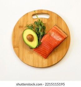 Ingredients Of Healthy Food. Fish, Avocado, Micro Green Pea Sprouts On A Wooden Cutting Board. Ketogenic Low Carbs Diet Concept.