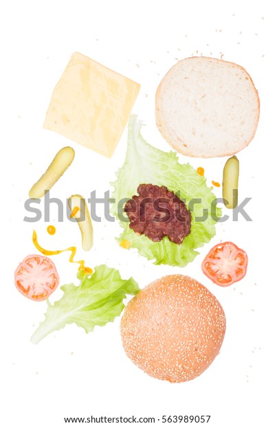 Ingredients for homemade fresh hamburger. On\
white background isolated. The view from the top. Vertical photos.\
Prepared for cooking. The food in the\
mess.