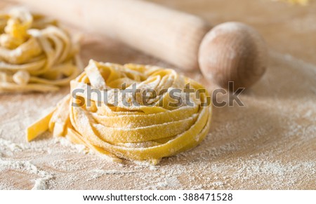 Ingredients for italian home made pasta; eggs and 
wheat flour on wood 