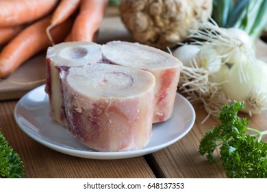 Ingredients For Making A Beef Bone Broth - Marrow Bones, Carrots, Onions, Parsley, And Celery Root