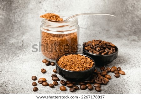 Ingredients for making coffee - coffee beans, ground and instant coffee on a black textured background. Caffeine. Decaffeinated coffee. Aroma energy hot drink. Place for text, space for copy.