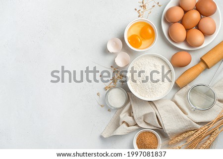 Ingredients for making dough dishes: cakes, cookies, pizza, pasta on a gray background. Flour, eggs, and sugar. Top view, copy space.