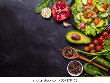 Ingredients For Making Salad On Rustic Black Chalk Board Background. Vegetable Salad In Bowl, Avocado, Tomato, Cucumber, Spinach. Healthy, Clean Eating Concept. Vegan Or Gluten Free Diet. Copy Space