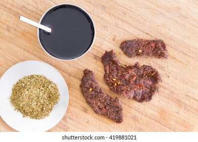 Ingredients For Making Traditional Beef Jerky Or Biltong With Oregano Herbs, Teriyaki Sauce And Thin Strips Of Lean Meat To Be Sun Dried