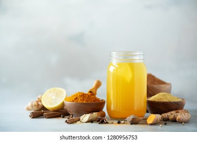 Ingredients for orange turmeric drink on grey concrete background. Lemon water with ginger, curcuma, black pepper. Vegan hot drink concept - Powered by Shutterstock