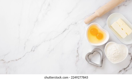 Ingredients and shapes for baking cookies on marble table. Concept cooking with love, cooking for your loved ones, baking for valentines day. Top view. Copy space - Shutterstock ID 2249277843