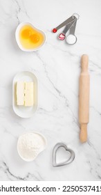 Ingredients and shapes for baking cookies on marble table. Concept cooking with love, cooking for your loved ones, baking for valentines day. Top view. Copy space - Shutterstock ID 2250537415