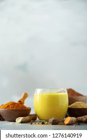 Ingredients for turmeric latte. Turmeric powder, curcuma root, cinnamon, ginger over grey background. Copy space, square crop. Spices for ayurvedic treatment. Alternative medicine concept