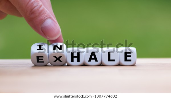 Inhale,Exhale concept. Hand turns dice and\
changes the word \
